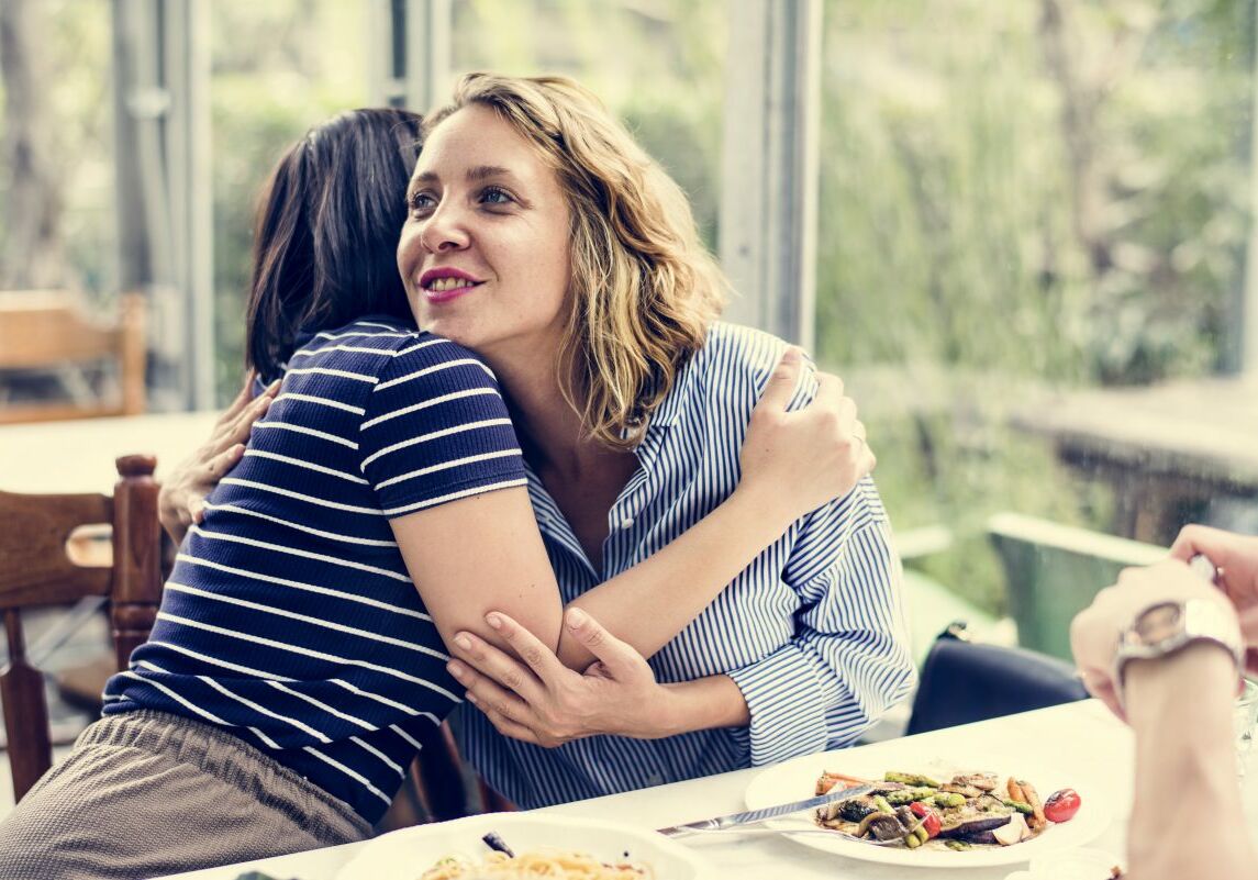 friends-hugging-at-a-restaurant-8HMU2YN-e1553568081613 friends-hugging-at-a-restaurant-8HMU2YN-e1553568081613